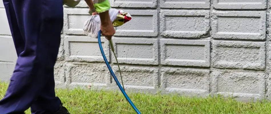 Professional applying perimeter pest to foundation of a home in Choctaw, OK.